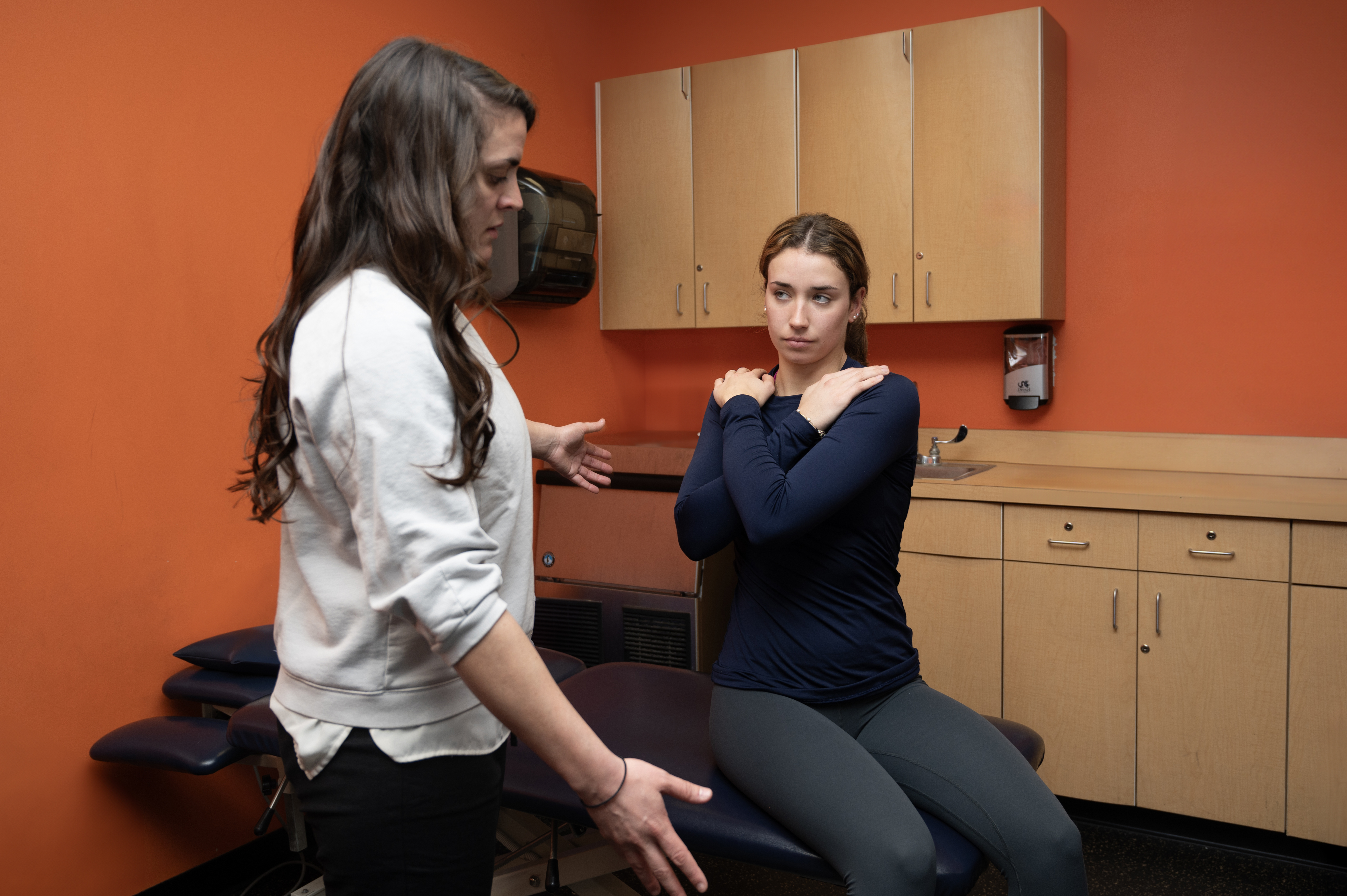 Physical therapist aids patient in exercise